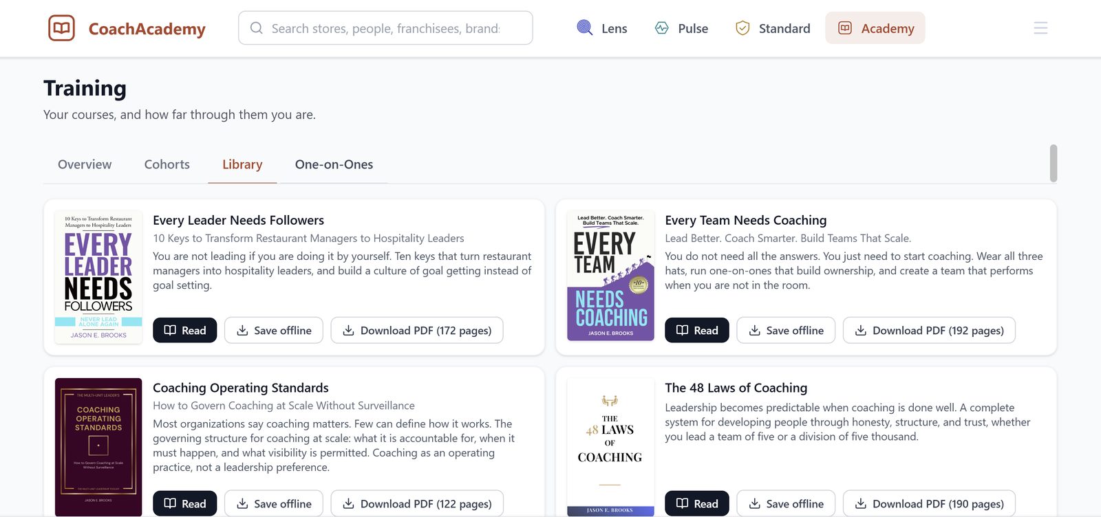 The CoachAcademy Library on a laptop: Every Leader Needs Followers, Every Team Needs Coaching, Coaching Operating Standards and The 48 Laws of Coaching, each with Read, Save offline and Download PDF buttons.